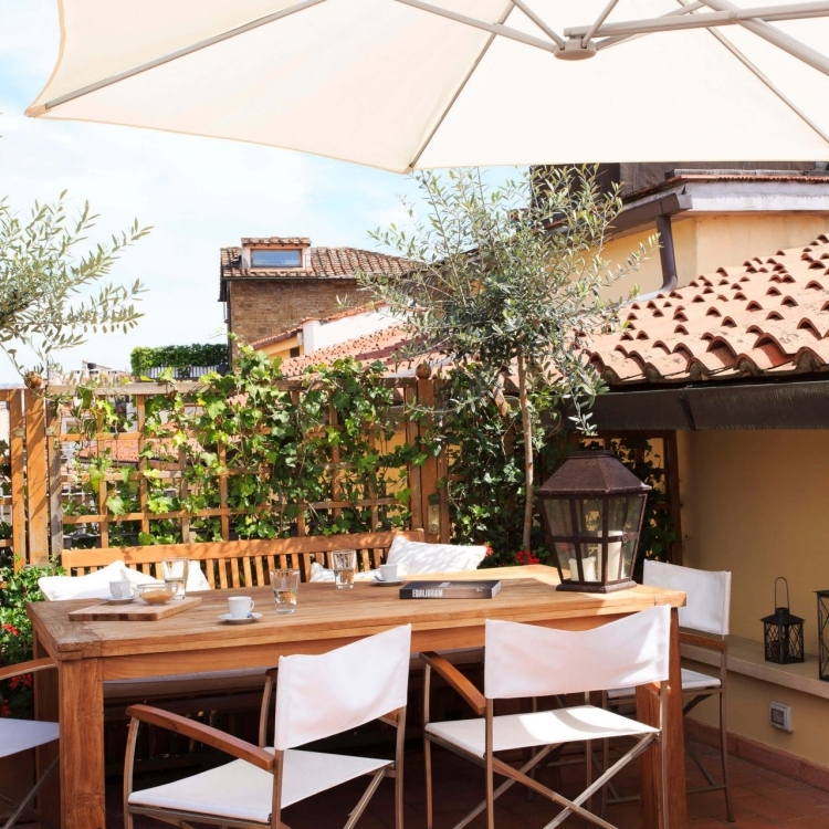Main terrace with dining table, sun umbrella, sun beds and gas grill.